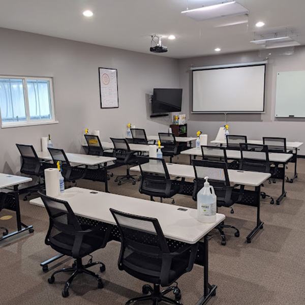 Clean classroom with tables, chairs, and training equipment.