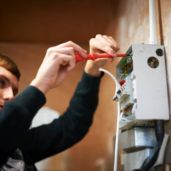 Instructor demonstrating electrical testing with safety gear.